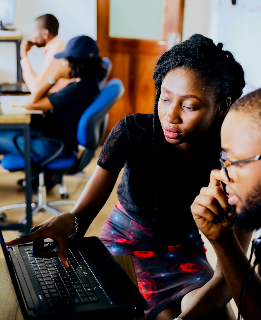 Two entrepreneurs reviewing work together on a laptop at a shared desk